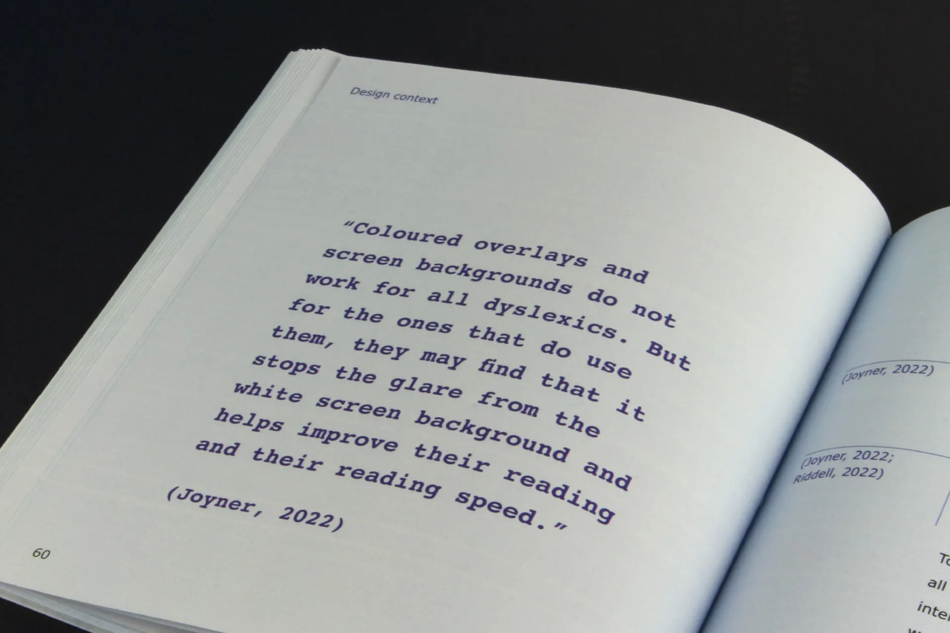 Close-up of a page from the dissertation with a quote on light blue paper